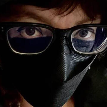 closeup of my eyes with black-rimmed glasses and a black mask
